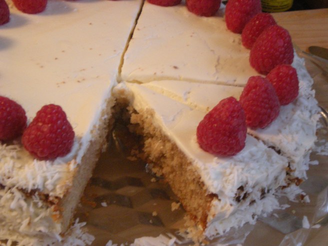Dowd and Rogers Gluten Free Dark Vanilla Cake  with cream cheese and coconut frosting, topped with raspberries